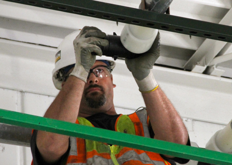 a live action shot of a contractor installing PEX in the Uponor manufacturing Annex building