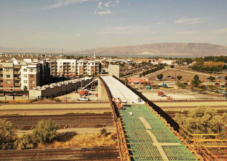 Aerial image of builders installing Uponor radiant snow-melt system within the UVU pedestrian bridge